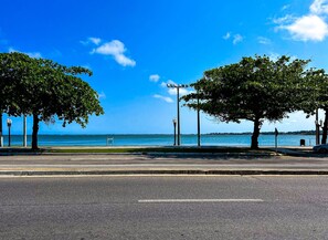 A coastal road with trees and a view of the sea. - Apto a 210m da Praia da Pontinha em Araruama RJ (Araruama)