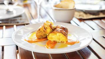 Un plato con un pastel y salsa sobre una mesa de madera.