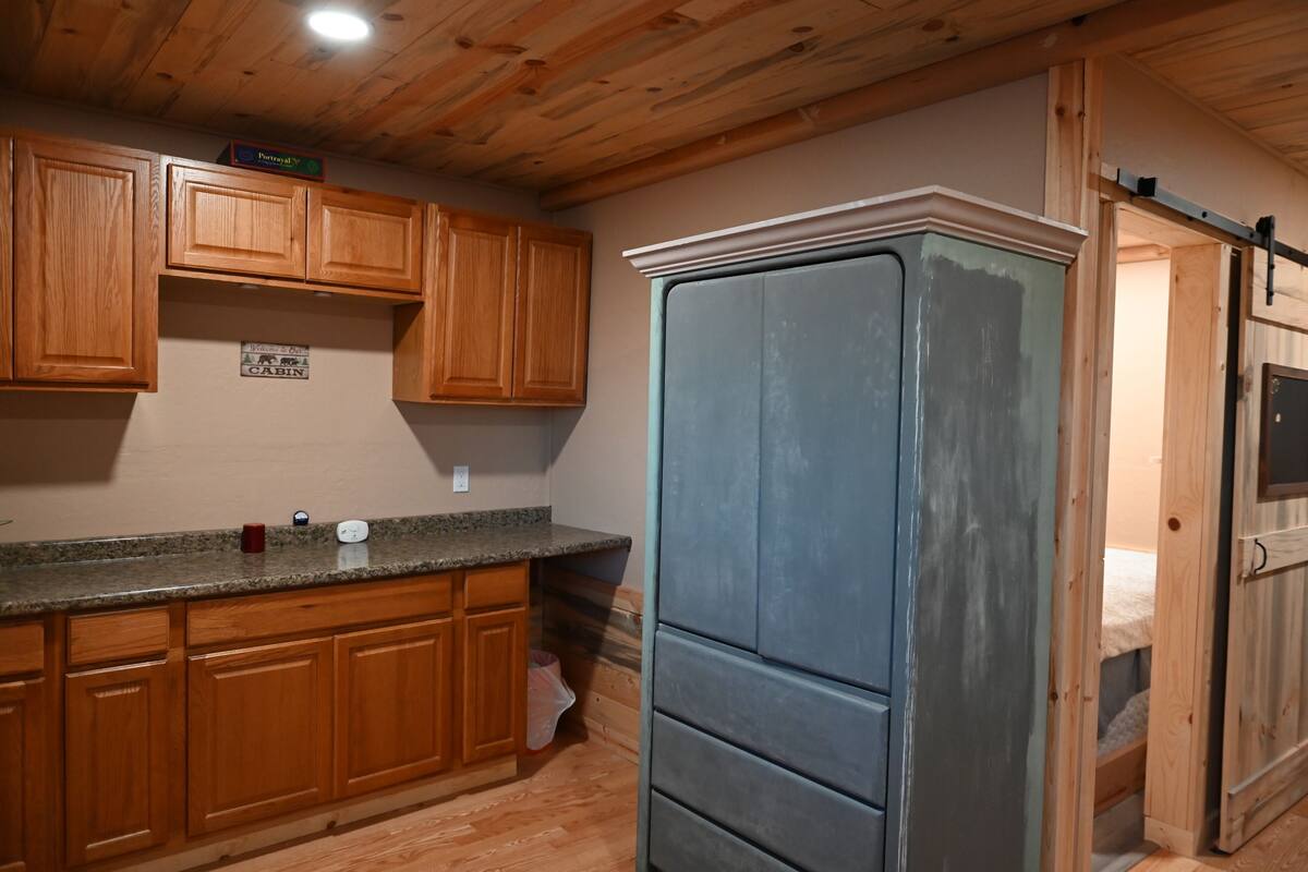 Une cuisine avec des meubles en bois, un plan de travail en granit et un réfrigérateur bleu.