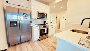 A modern kitchen with stainless steel appliances, a built-in microwave, and a water dispenser. - Daytona Double Delight (Daytona Beach)