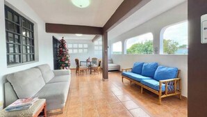 A spacious living area with a sofa, a wooden bench, and a dining table with chairs. - Quiet & comfortable, 3/2, 5 beds free parking, sleep 9 (Ceiba)