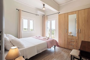 Une chambre à coucher avec un lit, une chaise, une armoire et une fenêtre.