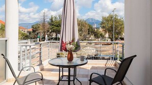 A balcony with a table, chairs, and a hanging umbrella. - Studio with Balcony Steps from Filiatra Square (Filiatra)