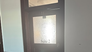 Une porte avec un panneau en verre dépoli et l’inscription « Suite 2 » dessus.