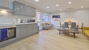 A modern kitchen with grey cabinets, a built-in microwave, and a large window. - Beauchamp House, 2-bed apartment Covstays (Coventry)