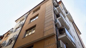 A multi-story building with a beige facade, multiple balconies, and air conditioning units. - Hotel Leda (Sofia)