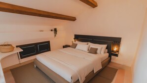 Un dormitorio con una cama grande, una mesita de noche y una lámpara de pared.