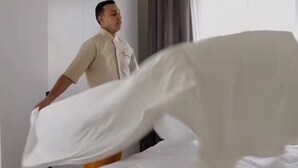 Una habitación de hotel con una cama, un ventanal con cortinas y una pared lisa.