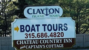 Letrero de Clayton Island Tours publicitando recorridos en barco, Chateau Country Inn y Captain's Cottage.