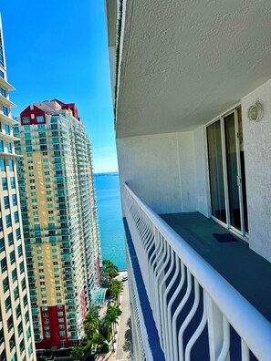 A high-rise building with a balcony overlooking a body of water.