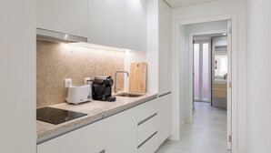 Une cuisine moderne équipée d’un grille-pain, d’une machine à café et d’une planche à découper en bois.
