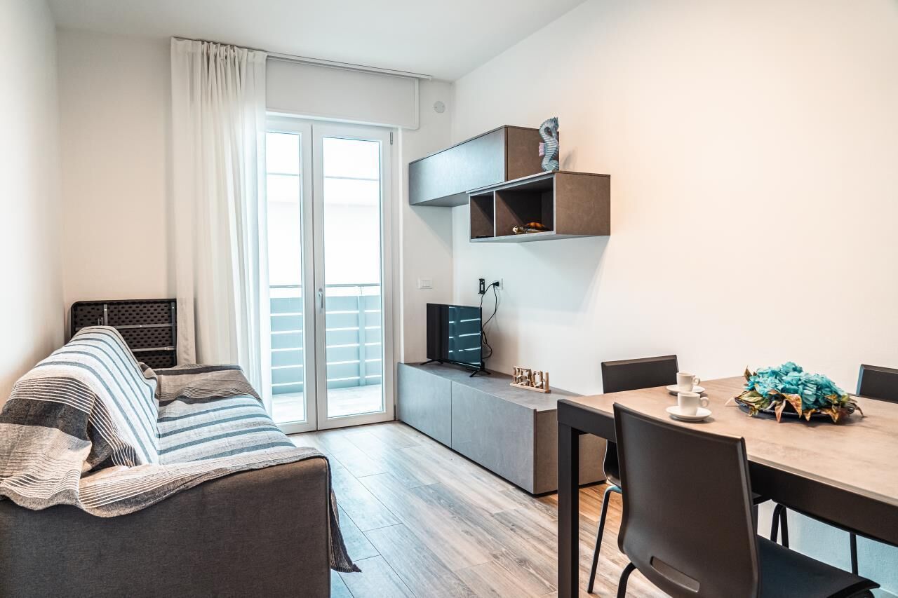 Un salon moderne avec un canapé, une table à manger et un téléviseur.