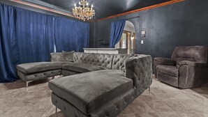 Een moderne woonkamer met een hoekbank, een chaise longue en een bruine fauteuil.