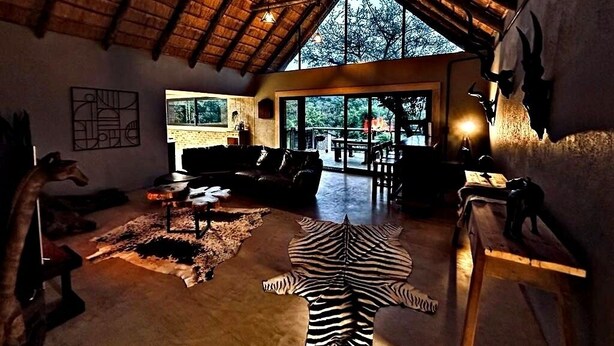Een ruime woonkamer met hoge plafonds, een groot raam en een zebra vloerkleed.