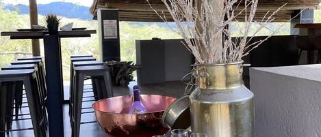 Una mesa de madera rústica con un cuenco de cobre, una jarra de metal y tres copas de vino.