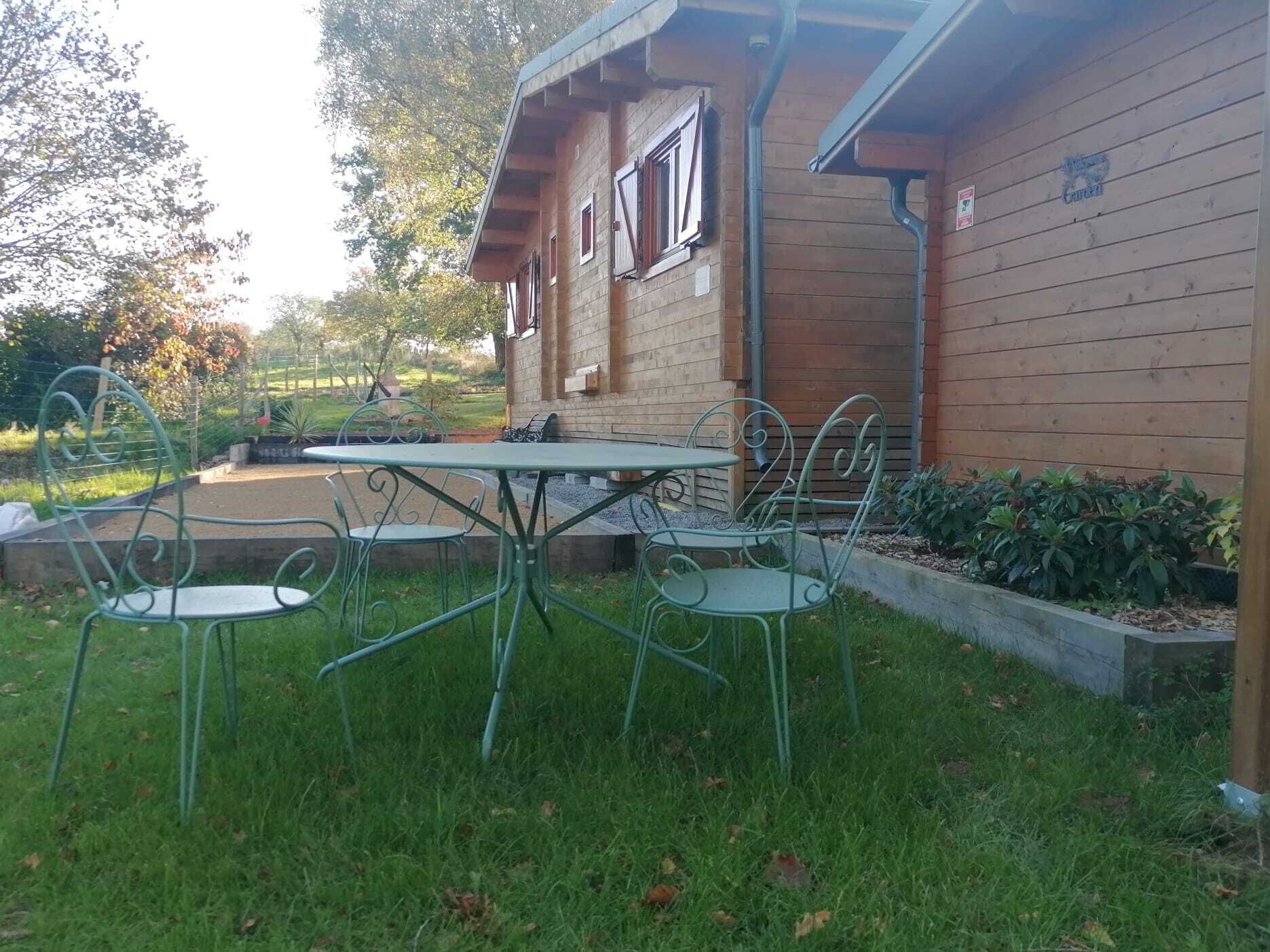Eine Holzdiele mit einer Terrasse, komplett mit Tisch und Stühlen.