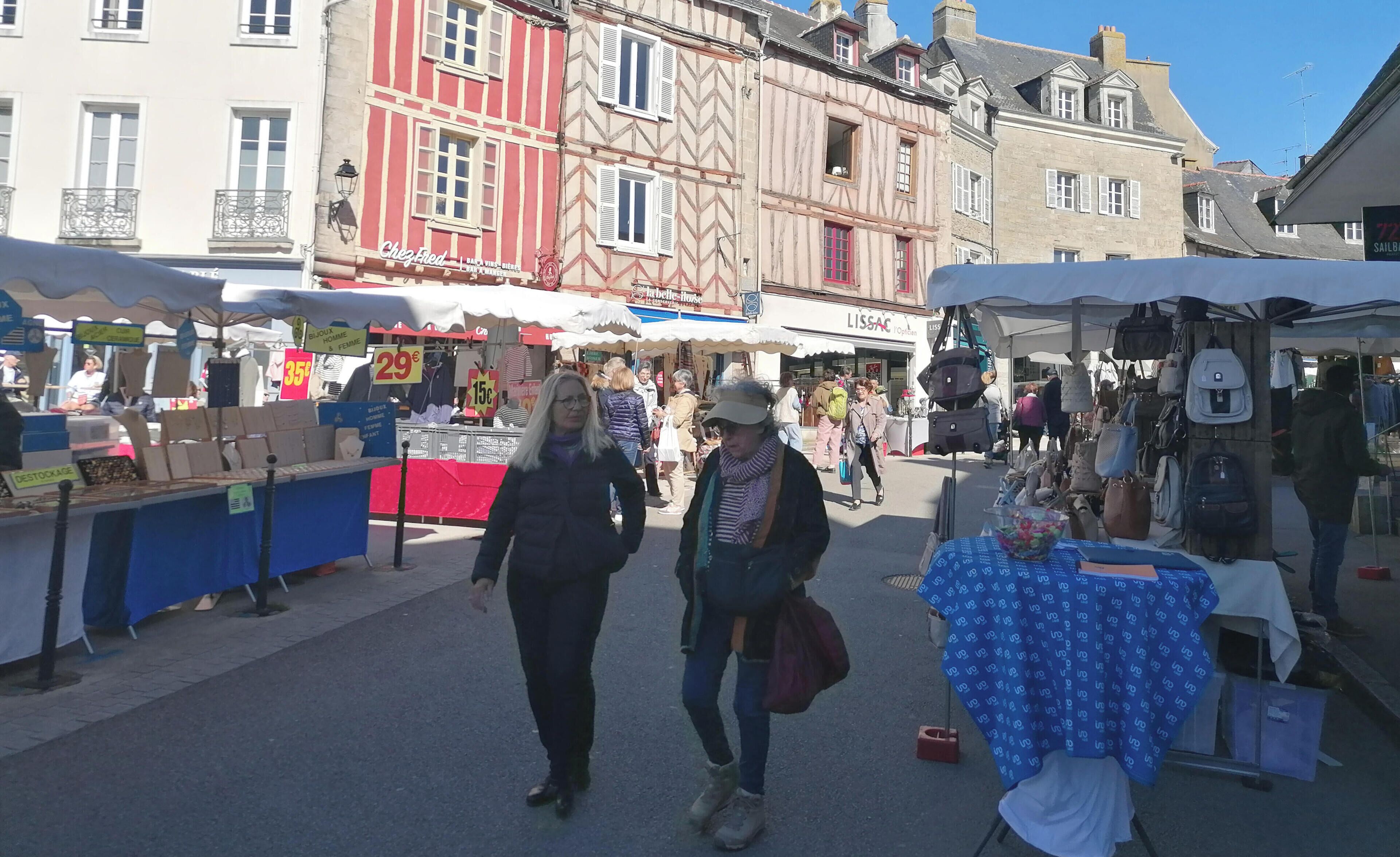 Een straatmarkt met verschillende kraampjes en mensen die lopen.