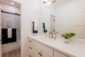 Regadera, secadora de cabello, toallas, papel de baño 