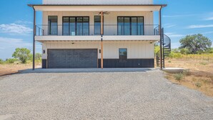 Un immeuble moderne à deux étages, doté d’un garage, d’un balcon et d’un escalier.