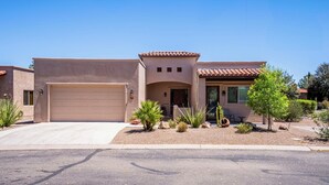 A two-story house with a beige facade, a red-tiled roof, and a garage. - Casita Paz at The Tubac Sanctuary (Tubac)
