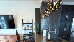 A modern kitchen with a central island, dark cabinetry, and pendant lighting.