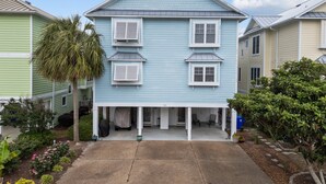 A two-story house with a covered porch and a garage. - Steps to the Sand in Carolina Beach, Sleeps 10! Villa (Carolina Beach)