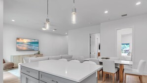A modern kitchen with a central island, white cabinetry, and pendant lighting. - Azul Townhomes A3 - Sunrise (Madeira Beach)