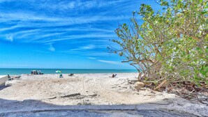 A beach with clear skies, a sandy shore, and a few people relaxing. - Azul Townhomes A3 - Sunrise (Madeira Beach)