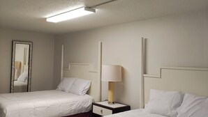 A hotel room with two beds, a nightstand with a lamp, a mirror, and a ceiling light. - Super Inn Motel (Oklahoma City)