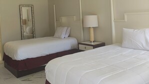 A hotel room with two beds, a nightstand with a lamp, a mirror, and a ceiling light. - Super Inn Motel (Oklahoma City)