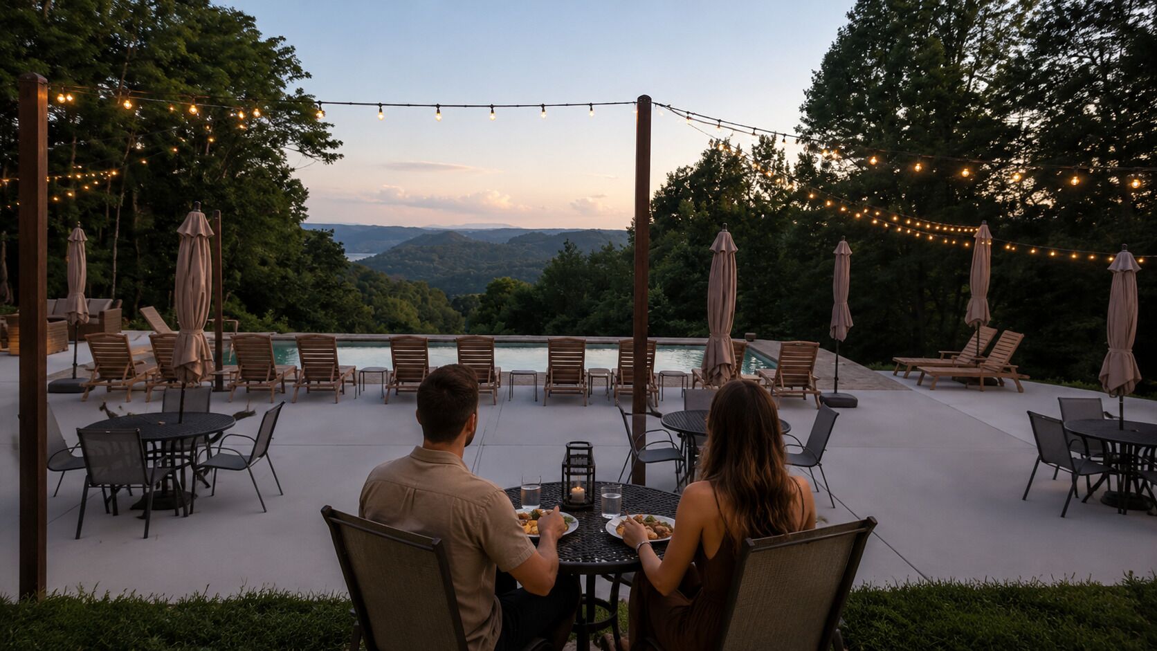 An outdoor patio with tables and chairs, string lights, and umbrellas.