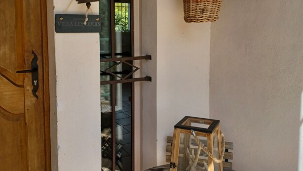 A wooden door, a glass door, a wicker basket, a lantern, and a small table.