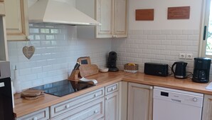 A kitchen with white cabinets, a dishwasher, and a countertop with a coffee maker and toaster.