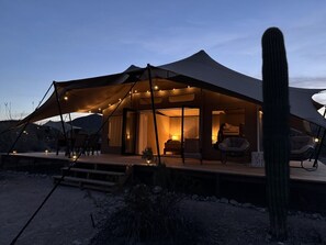 A tent with a bed, chairs, and a table, surrounded by a desert landscape. - Tent Ocotillos - occupancy near Saguaro NP (Marana)