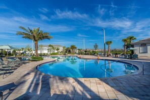 A pool area with lounge chairs, palm trees, and a clear blue sky. - Storeylake 5Bd Pool 5min Walking Clubhouse (Kissimmee)