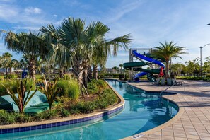 A swimming pool with a water slide, surrounded by palm trees and a tiled deck. - Storeylake 5Bd Pool 5min Walking Clubhouse (Kissimmee)