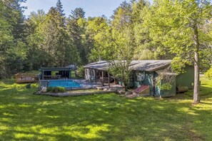 Ett hus med en swimmingpool, omgivet av en skog.