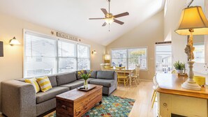 A living room with a gray sofa, wooden coffee table, and a ceiling fan.