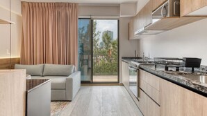 Eine moderne Küche mit Einbauofen, Mikrowelle und einem großen Fenster mit Blick auf eine Stadtlandschaft.