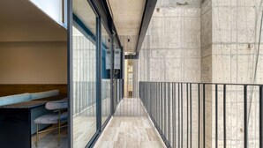A corridor with a bench, a railing, and a view of a building's interior. - New Loft near Reforma (Mexico City)