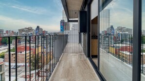 A balcony with a city view, metal railing, and a concrete floor. - New Loft near Reforma (Mexico City)