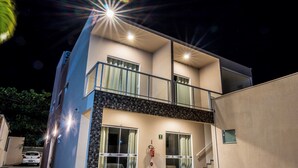 Un bâtiment moderne à deux étages, doté d’un balcon, de grandes fenêtres et d’un extincteur.