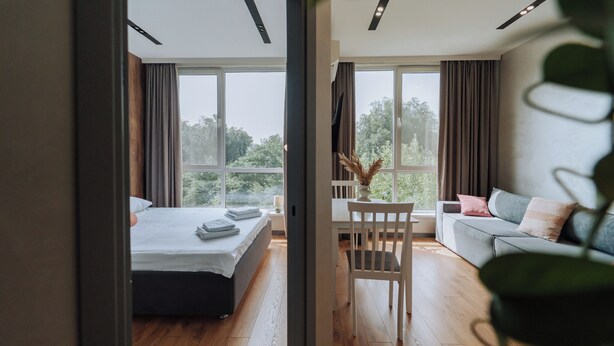 Ein modernes Schlafzimmer mit einem Bett, einer Couch und einem Esstisch.