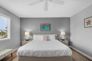 A bedroom with a bed, bedside tables, a ceiling fan, and a window with blinds. - Southbay by the Gulf #71 (Destin)