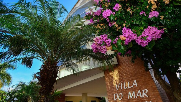 Villa do Mar, a building with a brick facade and a sign indicating its name and number. - Cobertura em Jurerê a 200m da praia (Florianopolis)