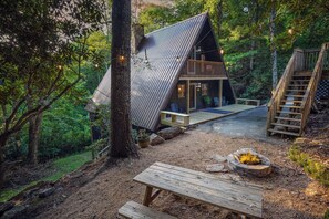 A cabin with a sloped roof, wooden deck, and a fire pit. - URSUS, A Secluded AFrame Chalet close to the resort! (Beech Mountain)