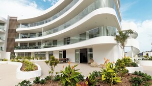 Un edificio moderno con varios pisos, amplias ventanas de vidrio y una fachada curva.