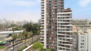 Un edificio de gran altura con varios pisos, balcones y un diseño arquitectónico moderno.