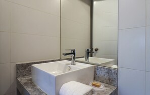 Une salle de bain avec une grande baignoire blanche, un lavabo double et un comptoir en marbre.