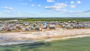 A coastal residential area with beachfront properties, a clear sky, and a distant view of the horizon. - Salty Sisters (Port St. Joe)